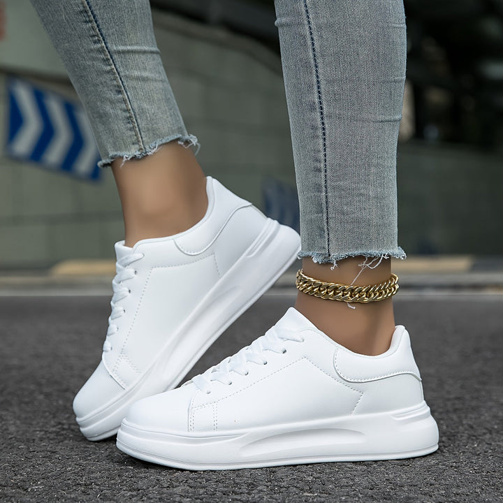 Ein Paar weiße Damensneakers, vielseitig und bequem für Frühling, Sommer und Casual-Looks.