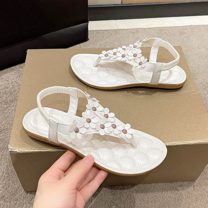 Nahaufnahme der weißen Damen Sandalen: T-Steg mit floralen Applikationen & Perlen.