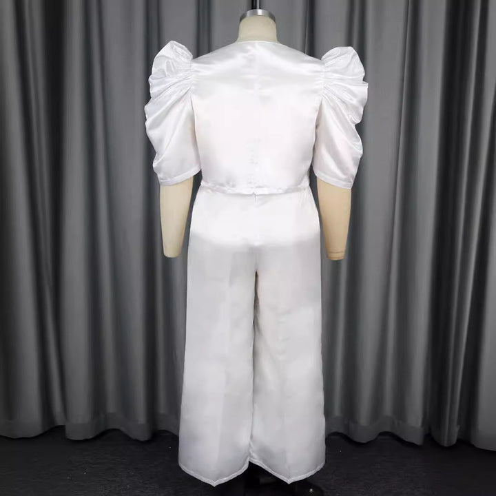 Eleganter weißer Damen Jumpsuit mit markanten Puffärmeln und figurbetontem Taillendetail. Moderner Fest-Look.