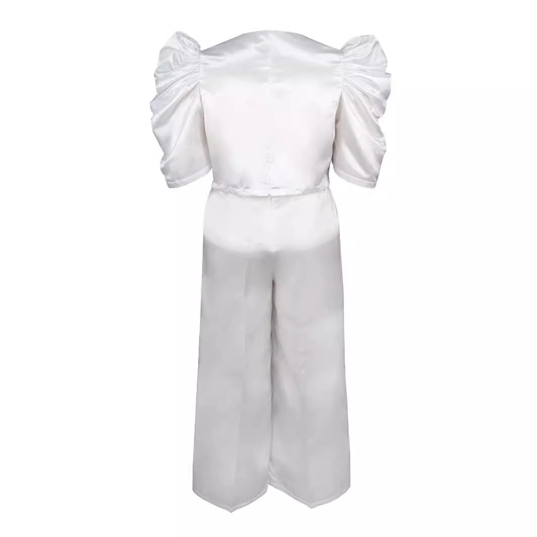 Detailansicht: Taillierter Damen Jumpsuit in Weiß mit eleganten Puffärmeln und weitem Hosenbein. Schicke Frauenmode.