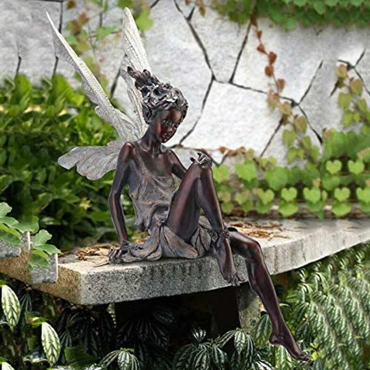 Anmutige Elfenfigur aus Harz, sitzt im Garten, bringt Zauber und Charme in Ihre Outdoor-Oase.