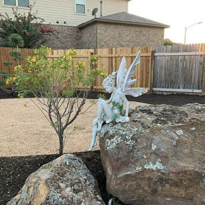 Märchenhafte Elfen Gartenfigur aus Harz inmitten von Blumen, verschönert jede Gartenecke.
