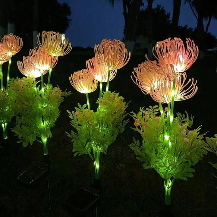 Dunkle Aufnahme der LED-Gartenleuchte Chrysantheme, die sanft leuchtet und eine romantische Atmosphäre schafft.