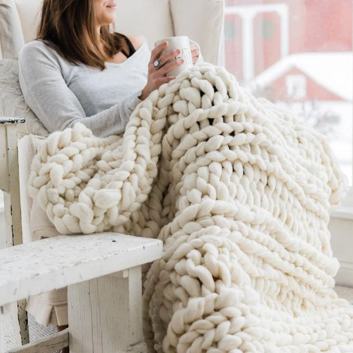 Selbstgemachte, gemütliche Kuscheldecke aus weichem Chunky Strickgarn für kalte Abende.