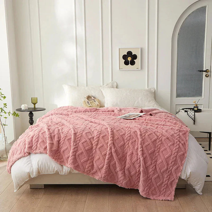 Gerollte Lammwolldecke, bereit für luxuriöse Wärme und Gemütlichkeit auf dem Sofa.